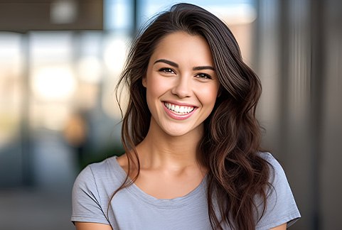 Closeup of woman in grey shirt smiling outside