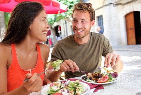 Couple smiling while eating lunch outside