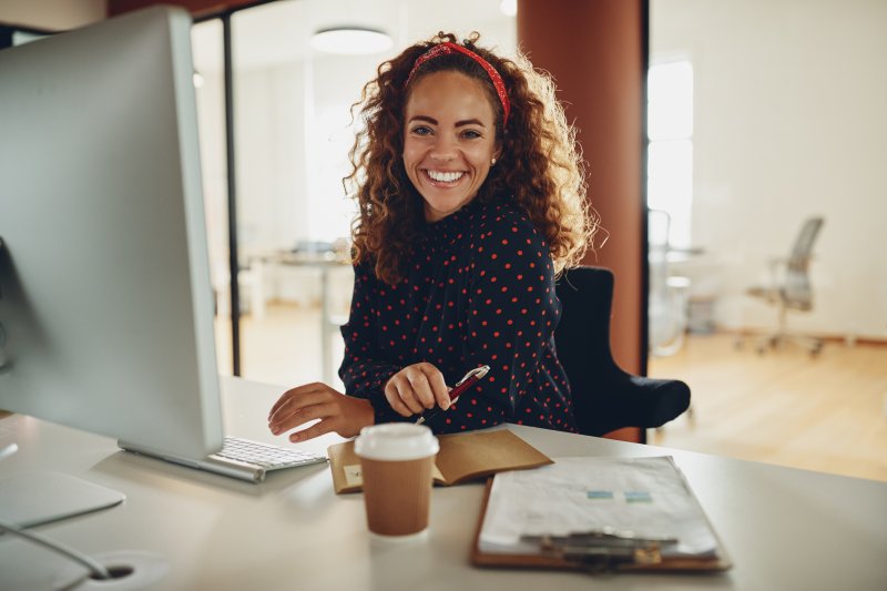 Woman smiling at a desk