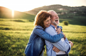 Couple embracing in a scenic field